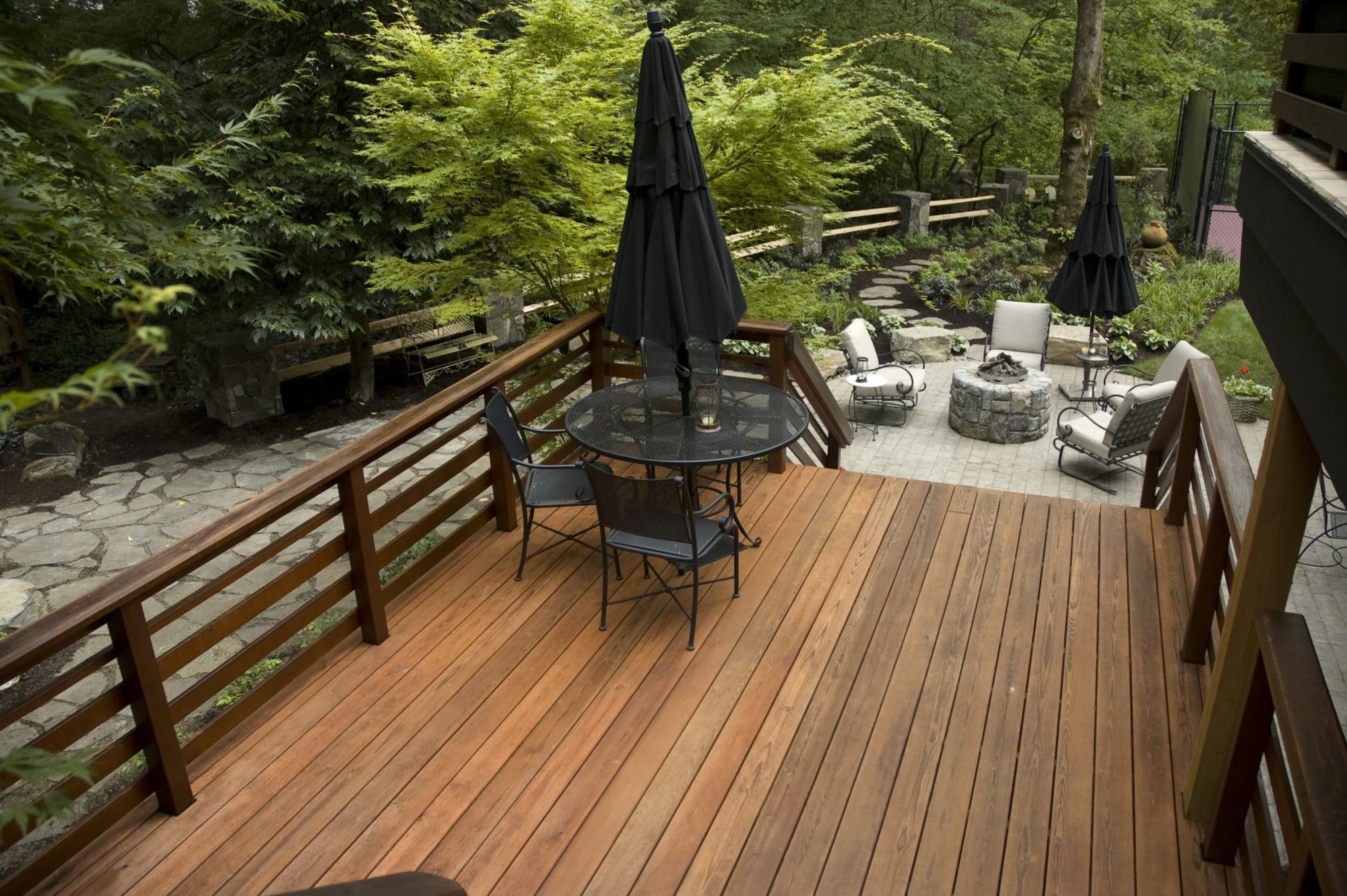 An outdoor deck with wood and a stone firepit