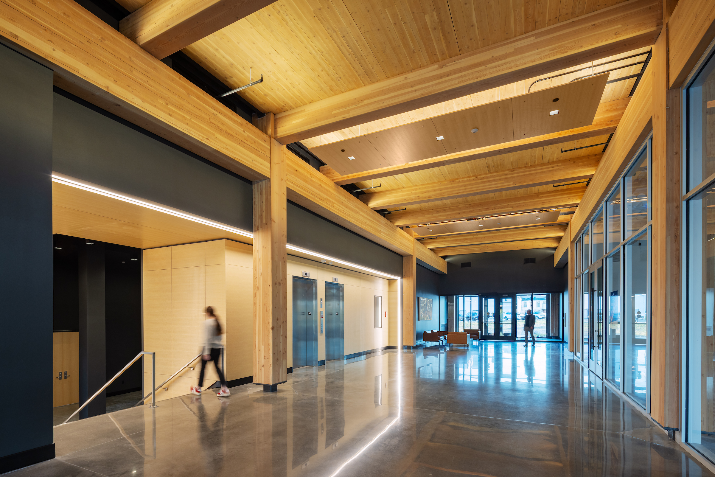 Interior of 1501 Mike Fahey with exposed mass timber columns, beams, and wood ceiling above an open lobby. located in Omaha, Nebraska.
