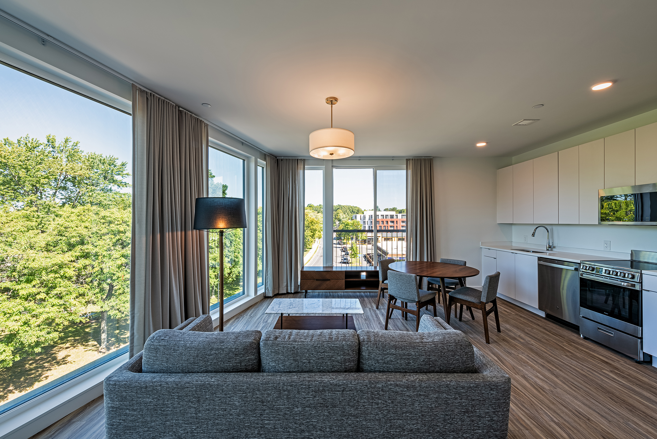 Furnished apartment at Eleven East Pleasant in Amherst, Massachusetts, with a living area overlooking large windows.