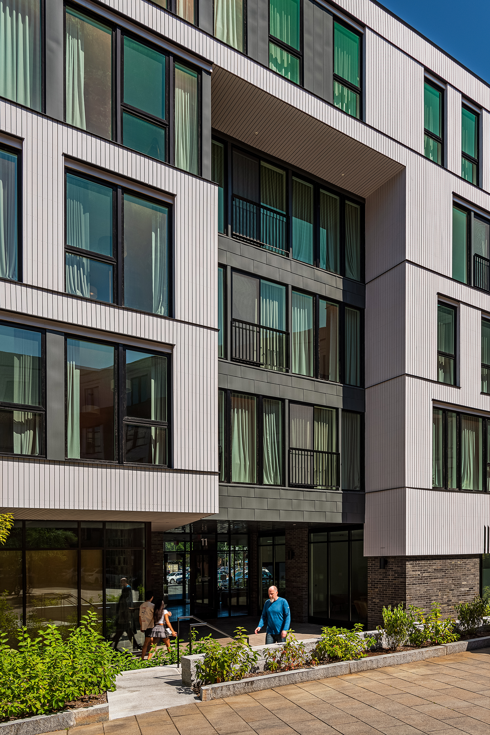 Close-up of the panelized facade at Eleven East Pleasant in Amherst, Massachusetts, with windows, wood siding, and metal cladding.