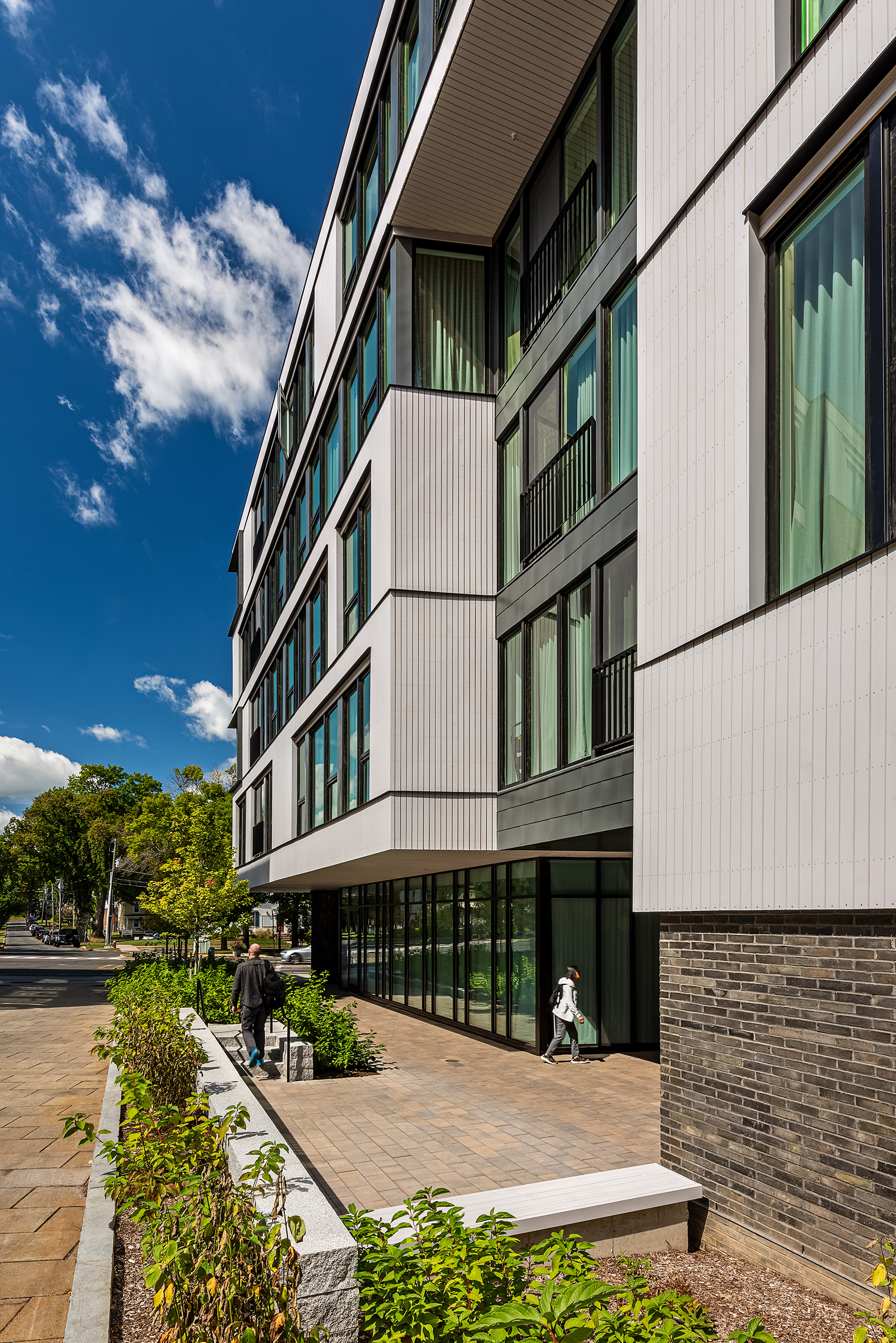 Side view of Eleven East Pleasant in Amherst, Massachusetts, showing its panelized facade and landscaped walkway.