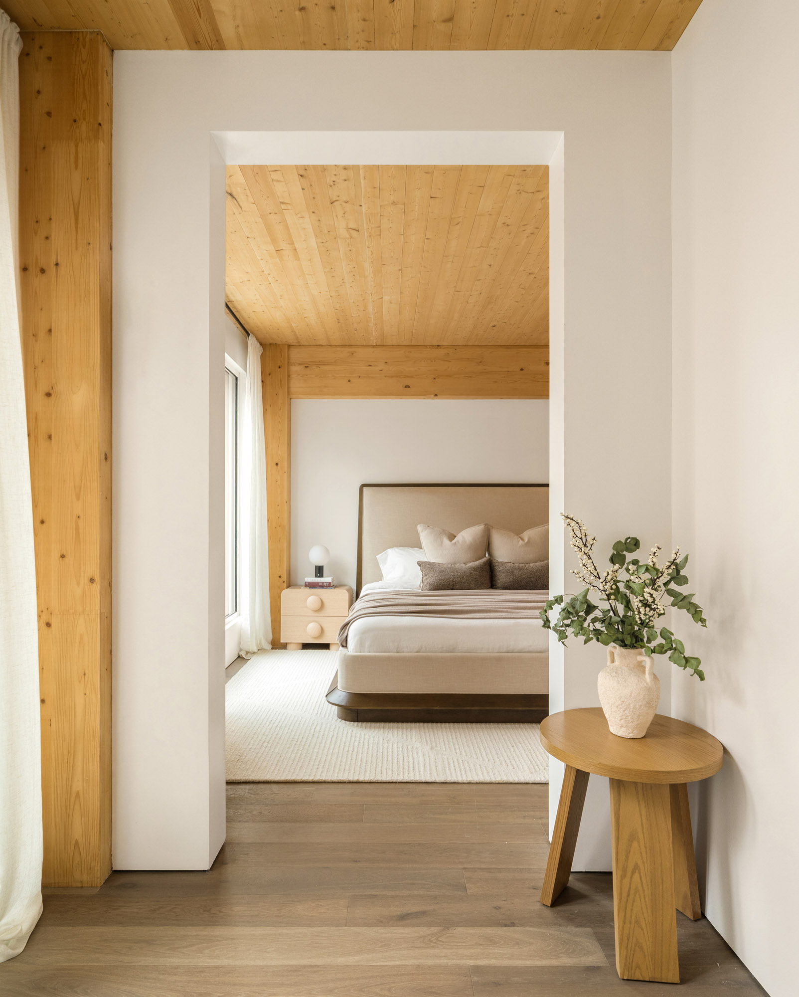 Bedroom at Timberburg in New York City, featuring exposed wood ceilings and structural timber columns surrounding a furnished sleeping area.