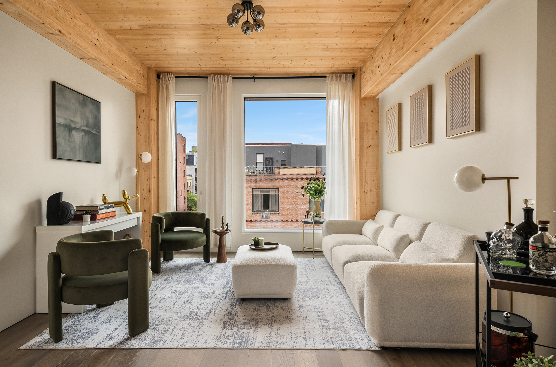 Living room at Timberburg in New York City, featuring exposed timber ceilings, glulam beams, contemporary furniture, and large windows.